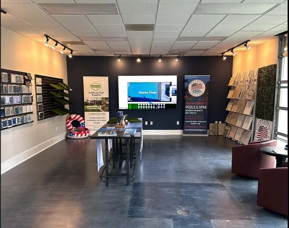 The Cornelius design-center interior contains finish displays, tables and a presentation screen.