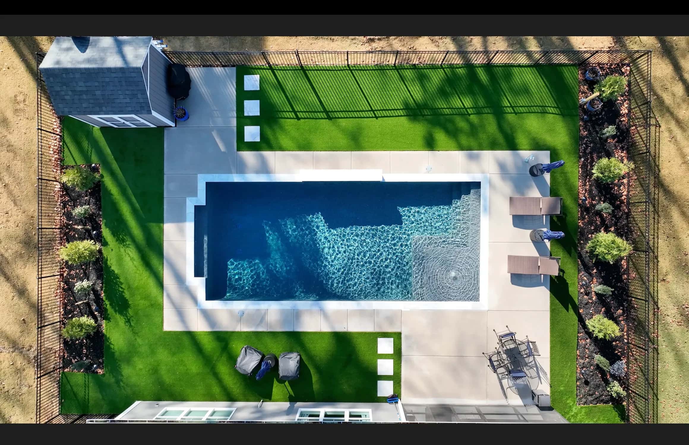An overhead photograph shows a rectangular pool with an adjoining spa and paved surroundings.