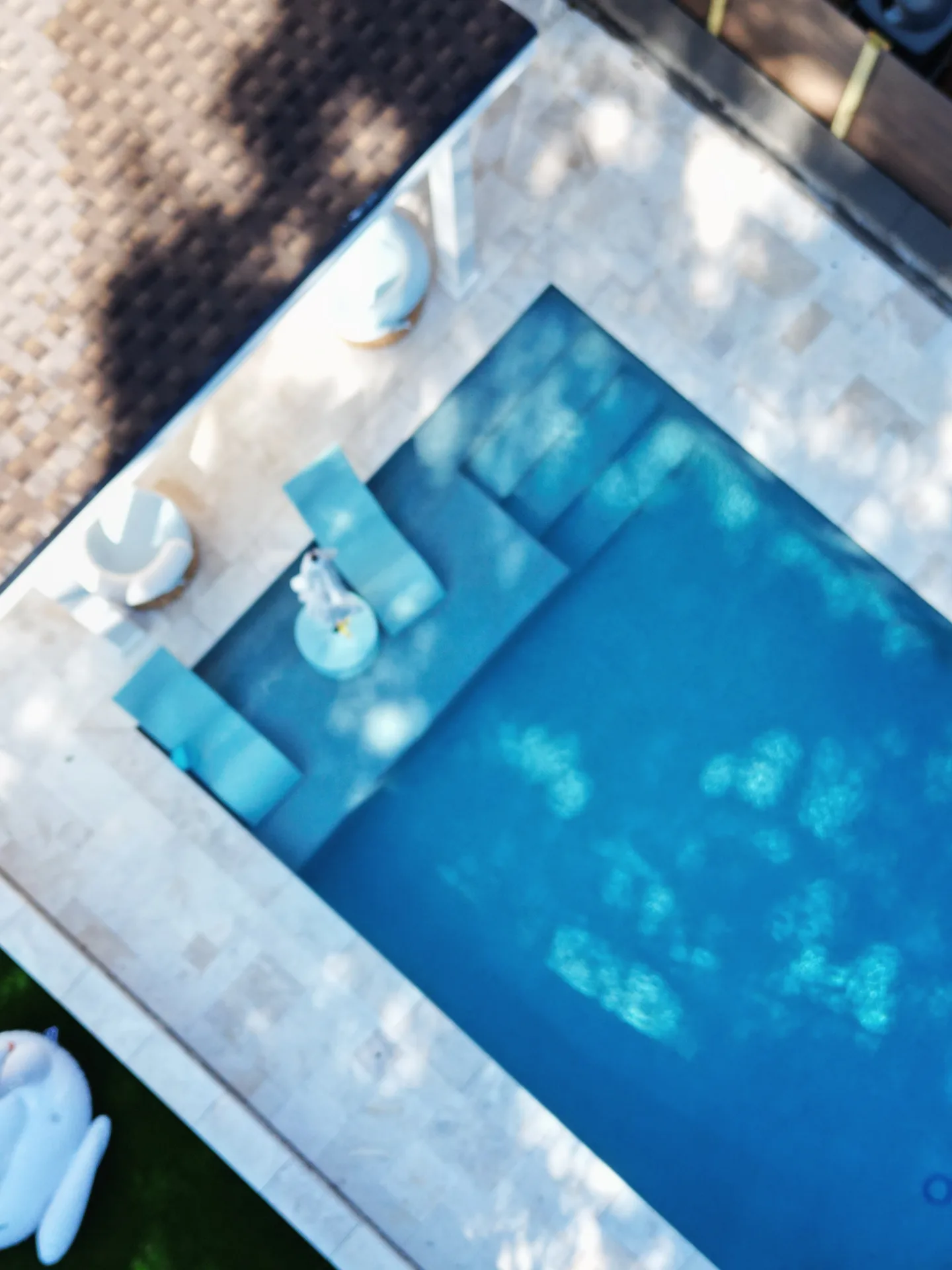 Overhead detail of the aqua sun-shelf loungers, pool entry steps and swimming space from the same Charlotte-area project