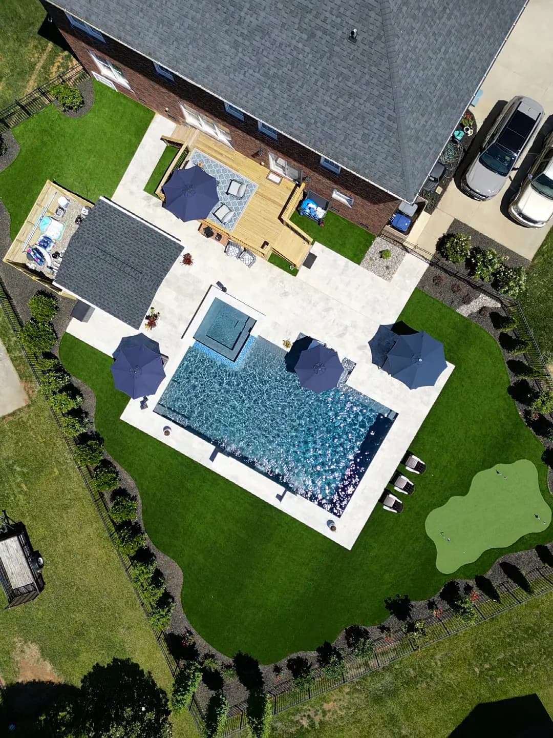 Aerial view of Patriot’s rectangular pool, raised spa, covered patio, artificial turf and putting green